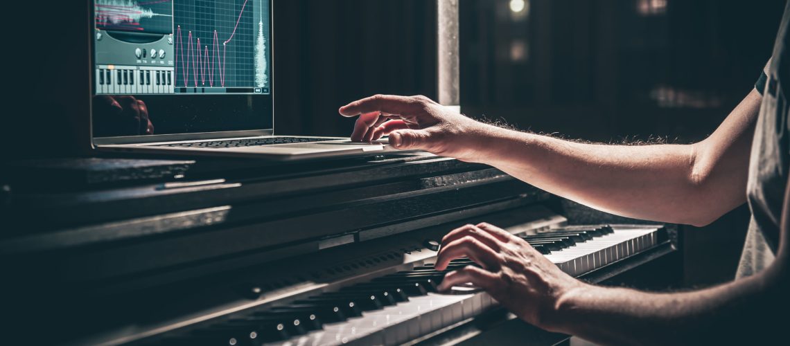 A man composer, producer, arranger, songwriter, musician hands arranging music on a computer at home studio, music production concept.